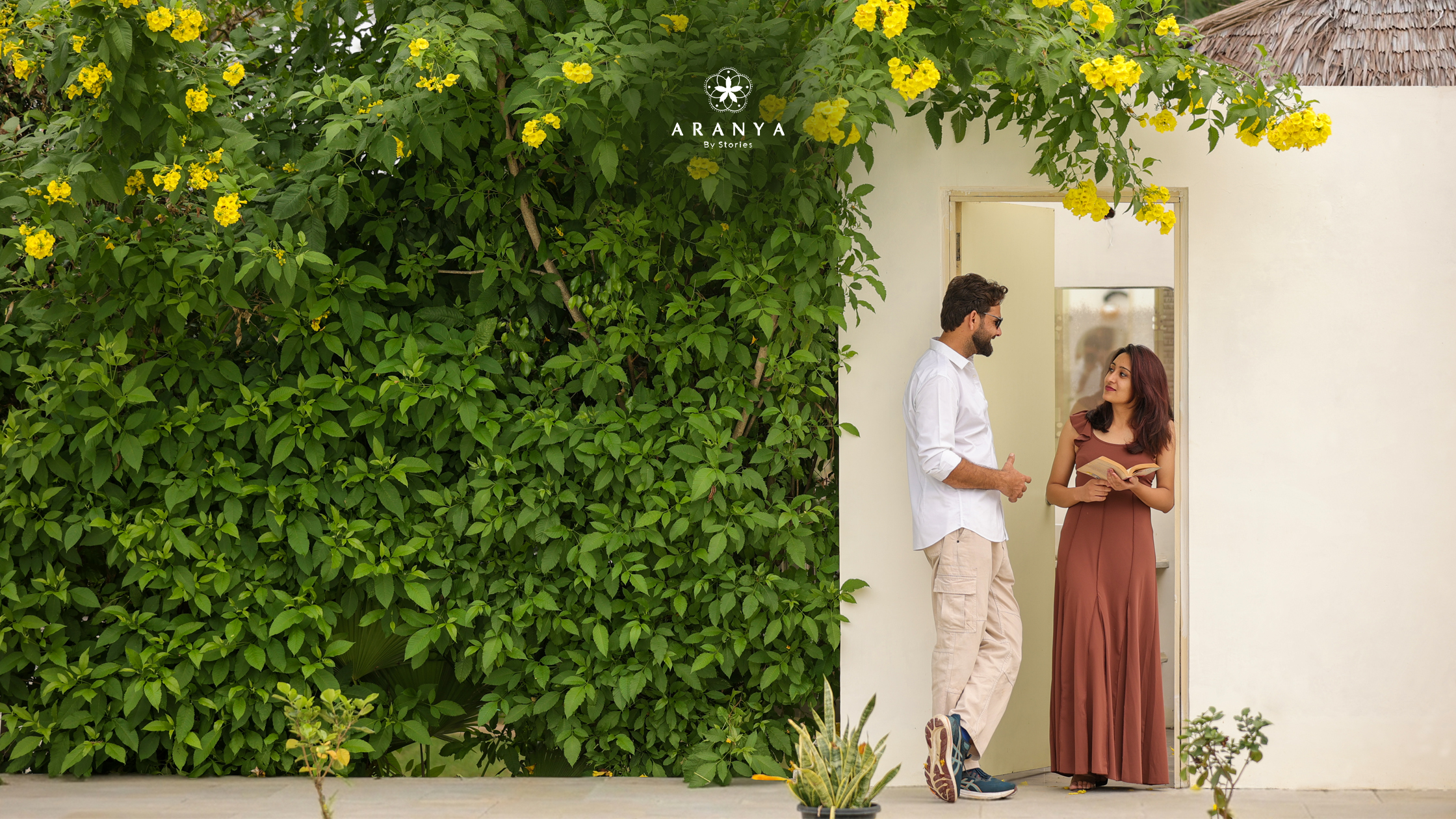 Couple relaxing beside lush greenery and blooming flowers at resort